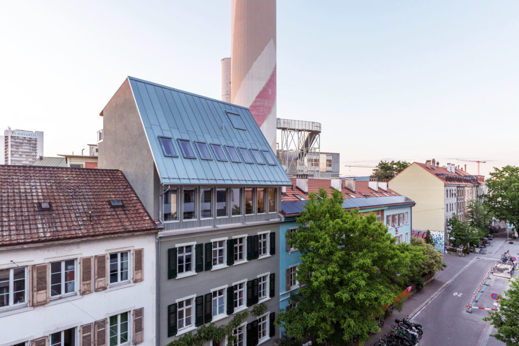 Die Attika als Vermittlerin und darüber das steile, zweigeschossige Metallfalz-Schrägdach © Armin Schärer / Architektur Basel