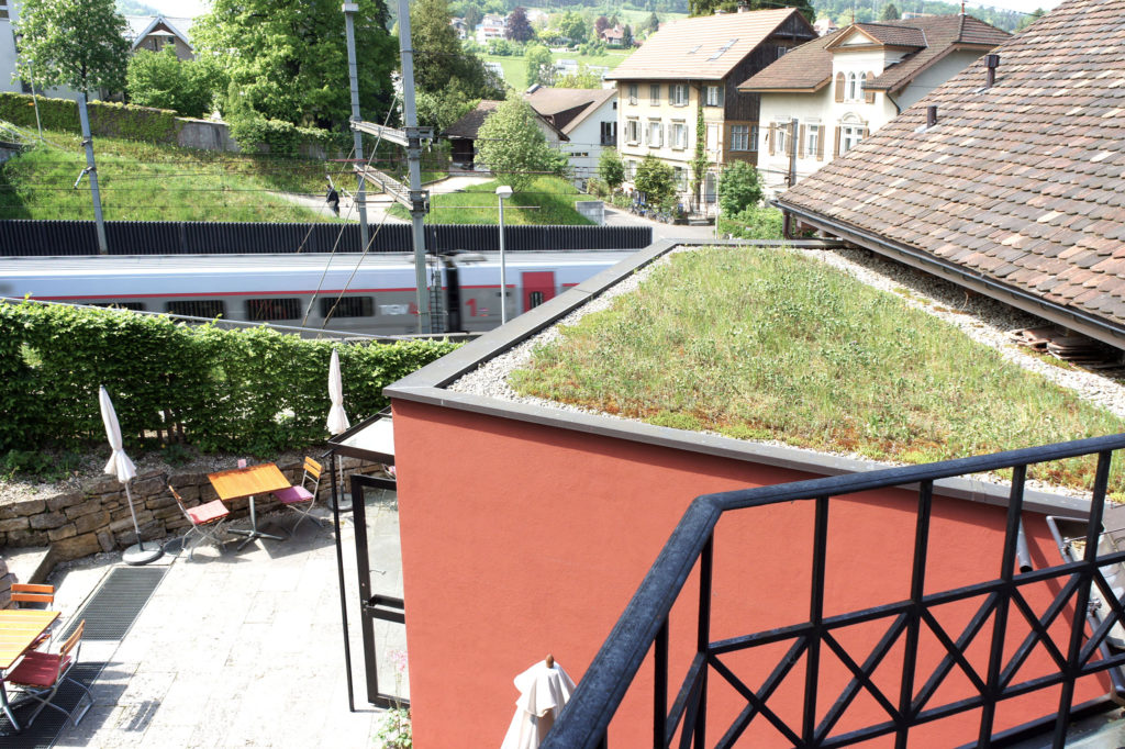 Der rückseitige Garten liegt direkt an den Geleisen – Kulturhotel Guggenheim, Liestal © Simon Heiniger / Architektur Basel